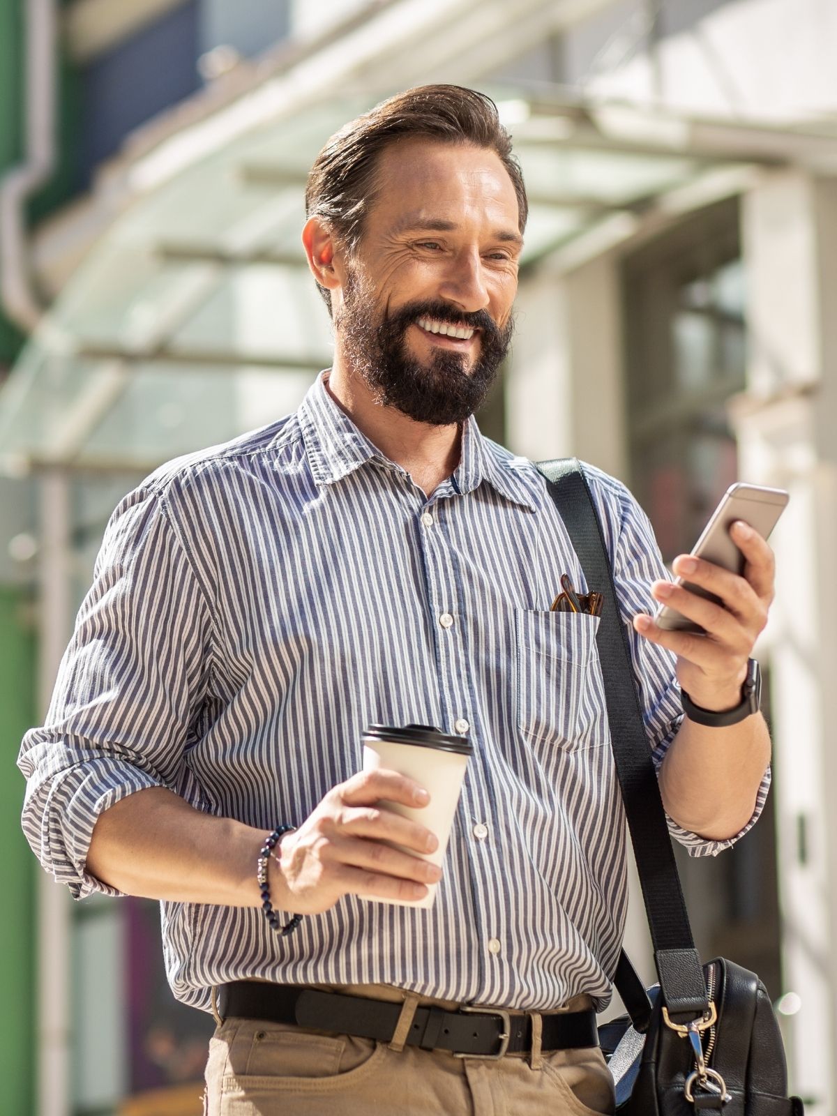 Man using his phone with a coffee